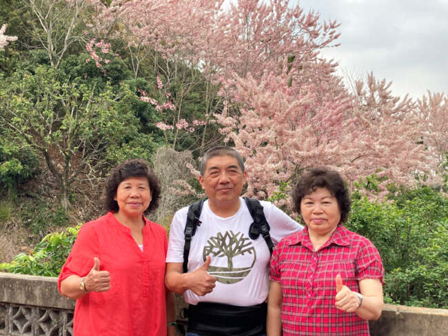 ▲竹崎鄉婦女會前理事長郭素貞(右一)及呂林綢合影於盛開的花旗木前。照片由台灣扶農協會提供。